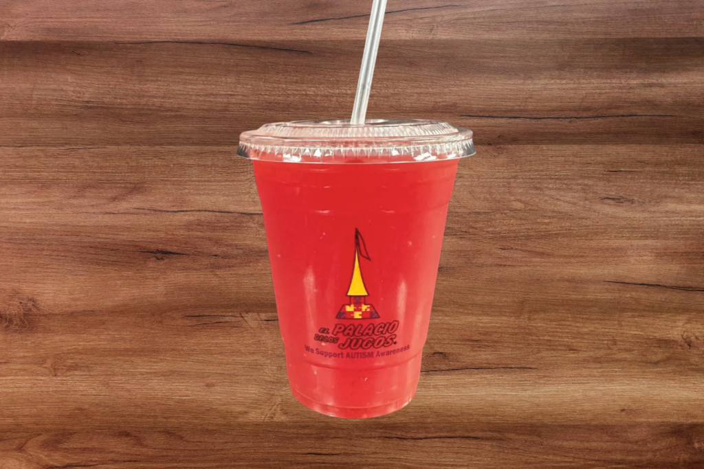 Grapefruit juice in a plastic cup with a straw to go.