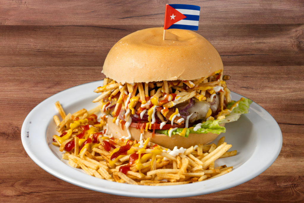 Frita Cubana (Frita cubana) con papas fritas (papas fritas). Pellizcado con la bandera cubana. 