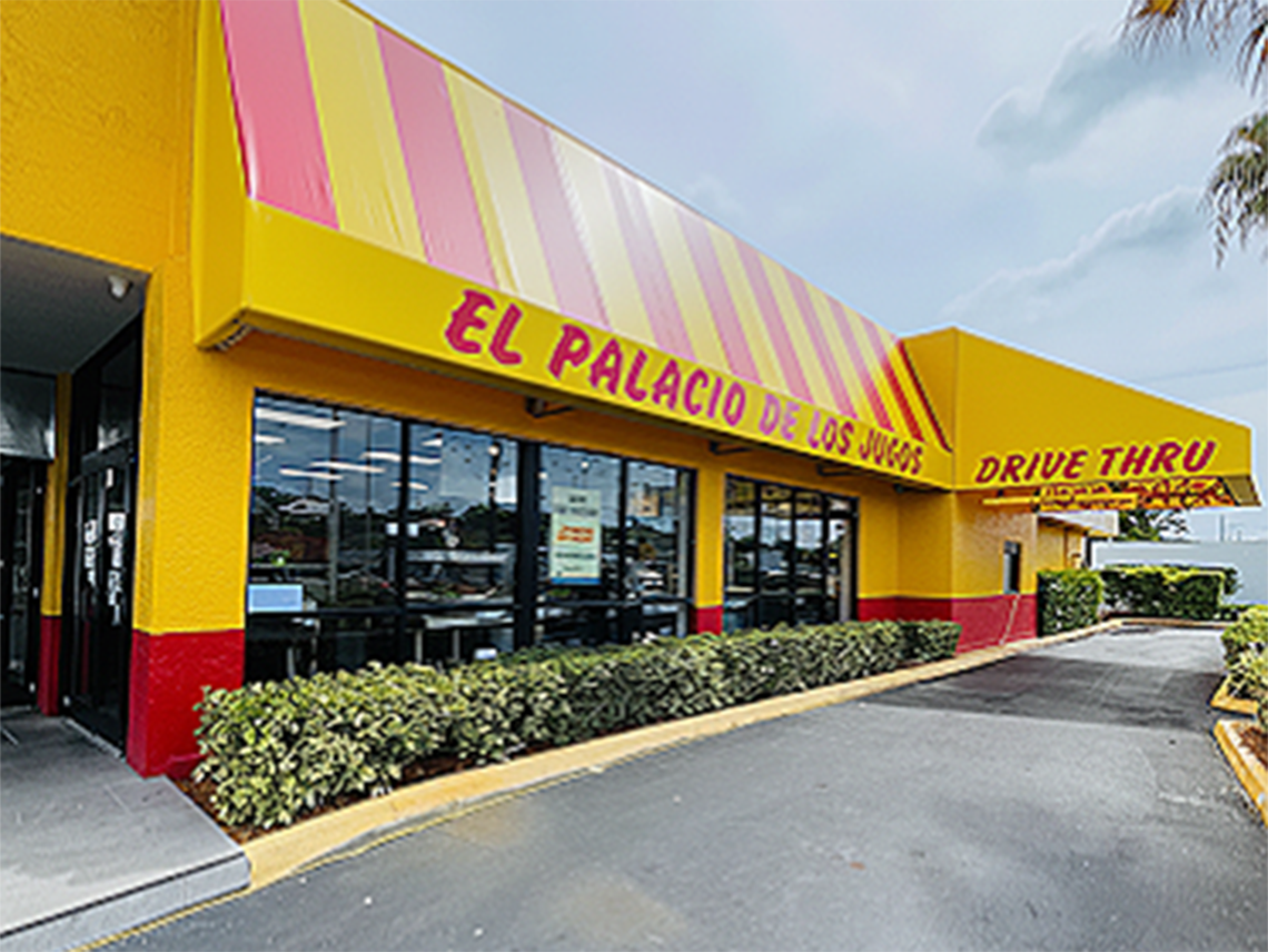 El Palacio de los Jugos in Miami Lakes, featuring its signature red and yellow awnings and a drive-thru lane.
