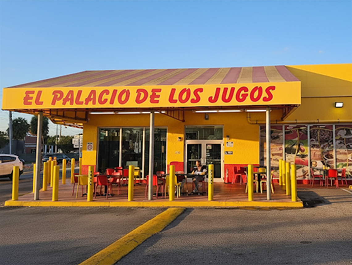 El Palacio de los Jugos at Sunset Blvd with signature red and yellow awnings. Open-air dining with red tables.